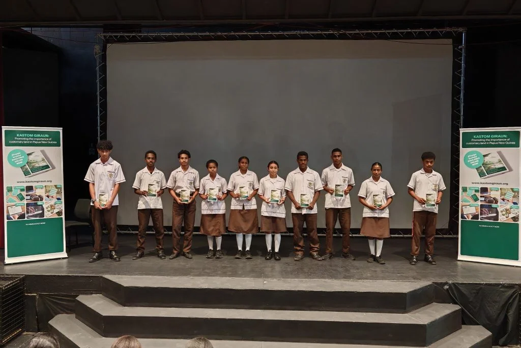 Students receiving the Kastom Giraun Booklet on stage
